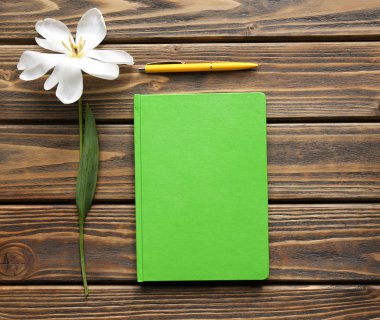 Defter ile ahşap arka plan üzerinde kalem ve Beyaz Lale