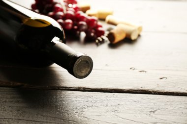 Cam şişe şarap mantarlar ve ahşap masa arka plan üzerinde üzüm ile