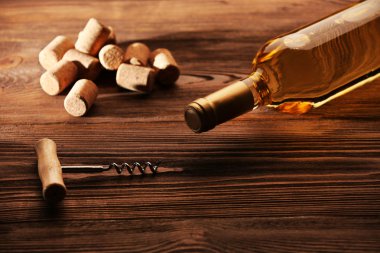 Cam şişe şarap mantarlar ve tirbuşon ahşap masa arka plan üzerinde