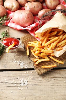 Tahtada patates kızartması, ahşap masa arkasında.