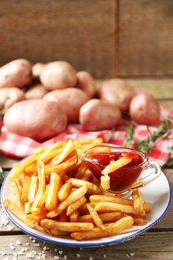 Ahşap masa arka plan üzerinde plaka üzerinde lezzetli Fransız kızartması