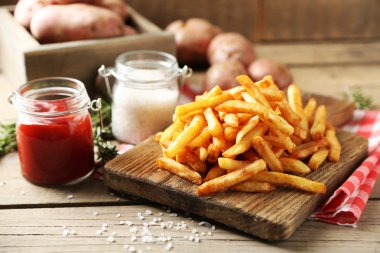 Tahtada patates kızartması, ahşap masa arkasında.