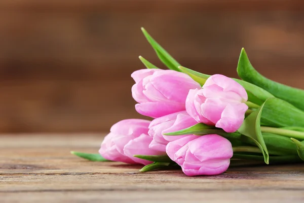 Belas tulipas rosa no fundo de madeira — Fotografia de Stock