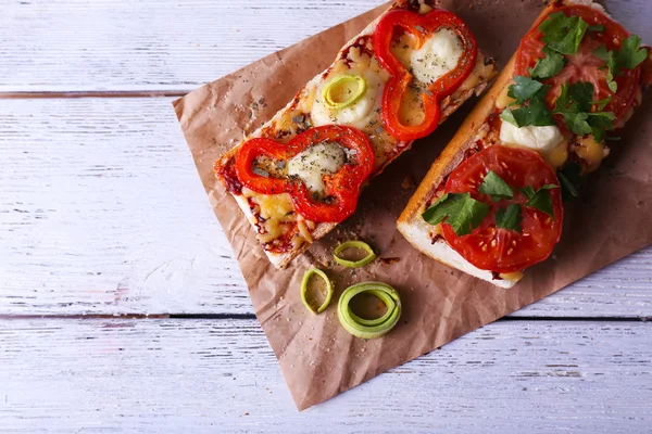야채와 나무 배경 종이에 치즈 맛 있는 샌드위치 — 스톡 사진