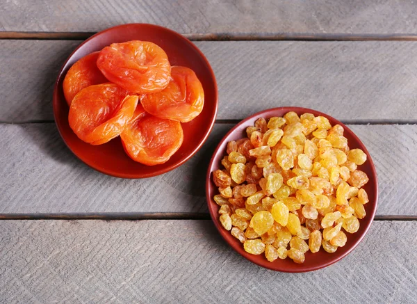 Сушеные фрукты в небольших тарелках на деревянном фоне — стоковое фото
