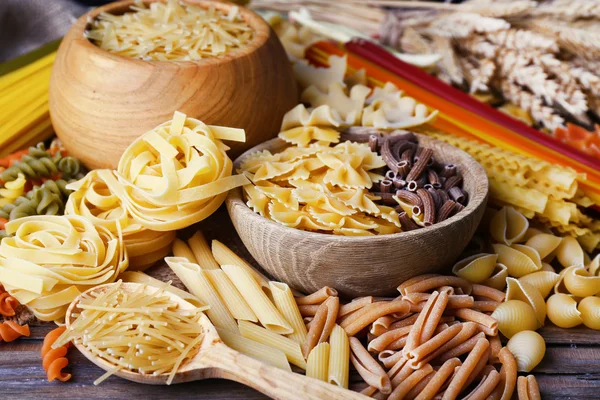 Verschiedene Arten von Pasta auf Holztischhintergrund — Stockfoto