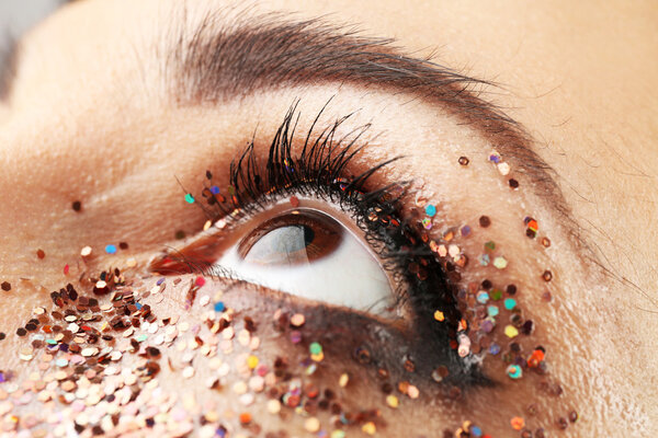 Female eye with fancy glitter makeup, macro view