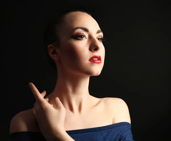 Retrato de mujer hermosa con maquillaje de brillo de lujo sobre fondo oscuro — Foto de Stock