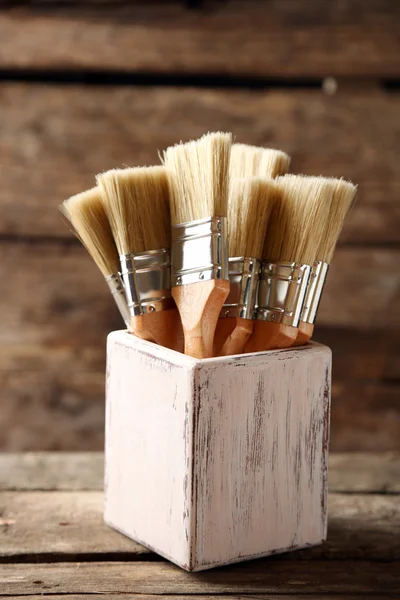 Paint brushes on old wooden background — Stock Photo, Image