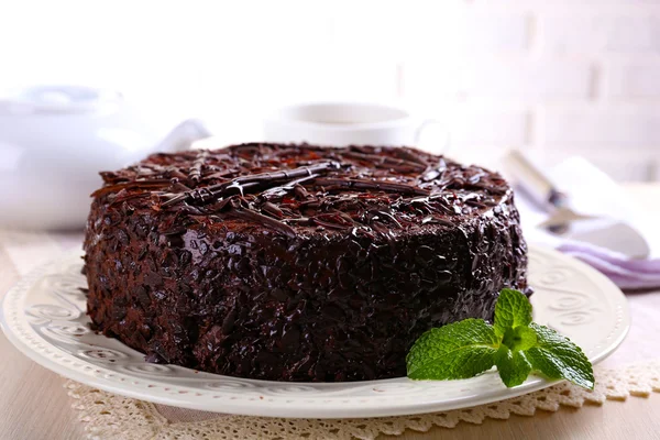 Gâteau au chocolat savoureux sur table sur fond de mur de briques — Photo