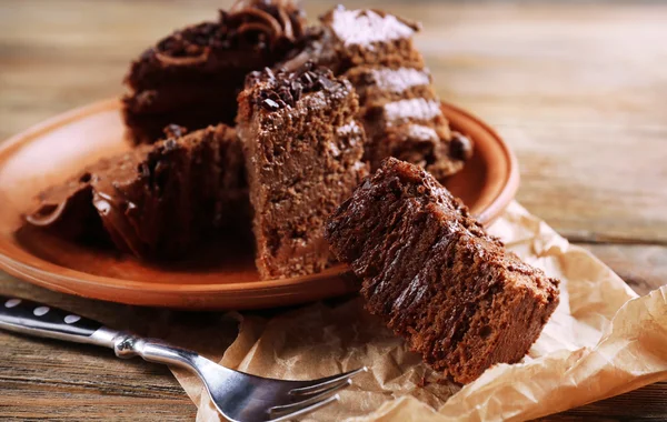 Slices of tasty chocolate cake on plate on table close up — Stock Photo, Image