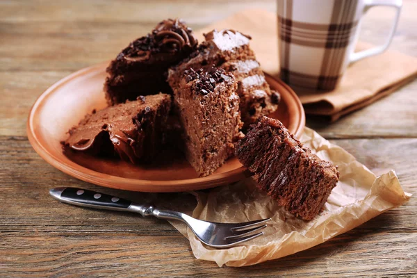 Fatias de bolo de chocolate saboroso na placa na mesa de perto — Fotografia de Stock