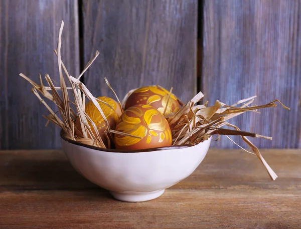 Påskägg i skål på trä bakgrund — Stockfoto