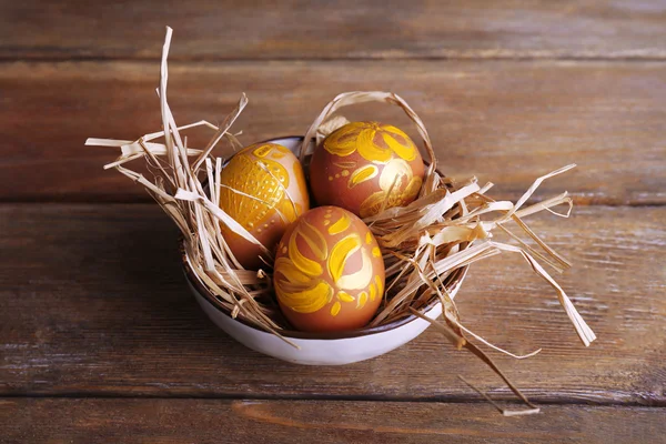 Uova di Pasqua in ciotola su fondo di legno — Foto Stock