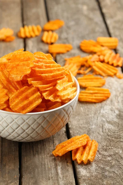 Heerlijke potato chips in kom op houten tafel close-up — Stockfoto