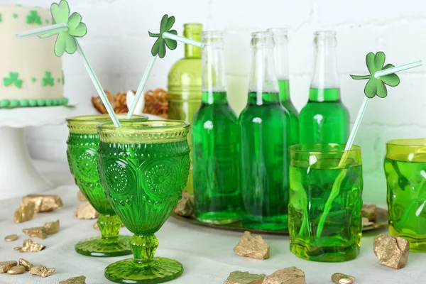 Composition for St Patrick Day with sweets and drinks on table on brick wall background — Stock Photo, Image