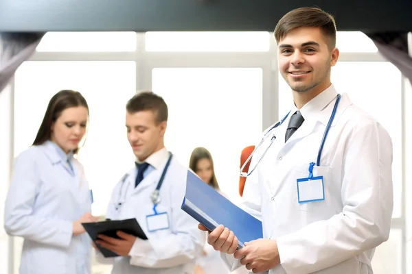 Aantrekkelijke mannelijke arts met team in vergaderruimte — Stockfoto