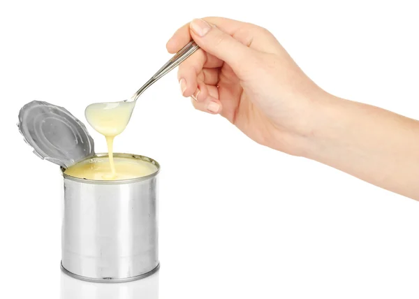 Tin can of condensed milk with spoon isolated on white — Stock Photo, Image