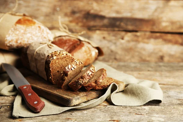 Verschiedene frische Brote, auf altem Holztisch — Stockfoto