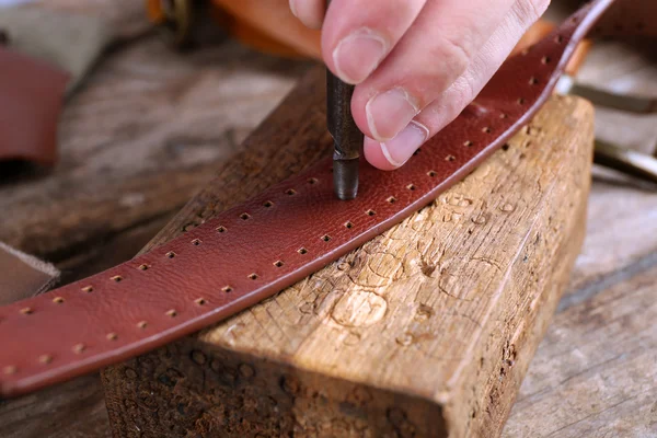 Repairing leather belt in workshop — Stock Photo, Image