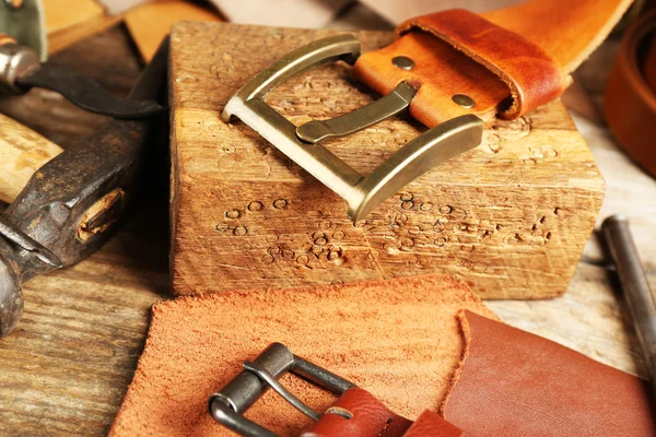 Craft tools with leather belt on table close up — Stock Photo, Image