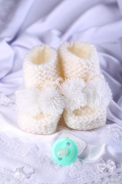 Weiße Babystiefel auf Tuch in Nahaufnahme — Stockfoto