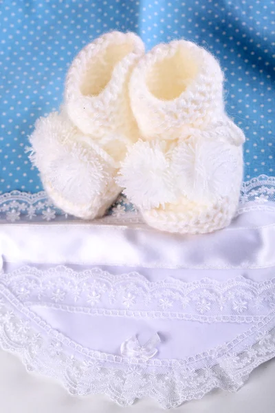 Weiße Babystiefel auf Tuch in Nahaufnahme — Stockfoto