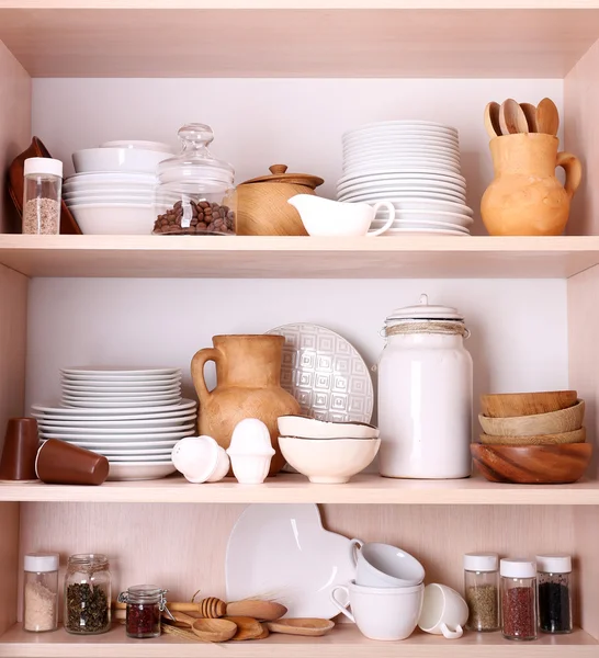 Kitchen utensils and tableware on wooden shelves