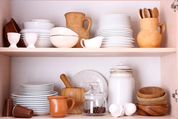 Utensilios de cocina y vajilla en estantes de madera —  Fotos de Stock