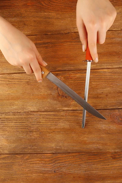 Procesu ostrzenia noża na drewniane tła — Zdjęcie stockowe