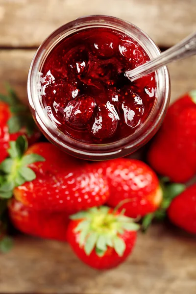 Pot aardbeienjam met bessen op tafel close-up — Stockfoto