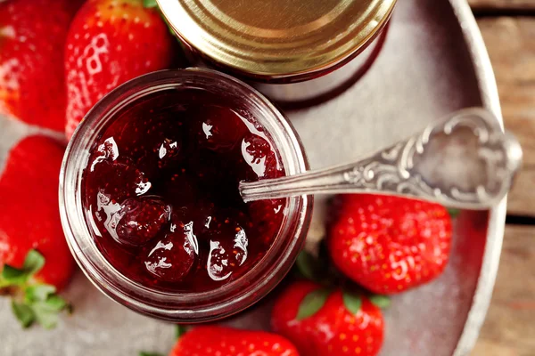 Gläser Erdbeermarmelade mit Beeren auf Tablett in Großaufnahme — Stockfoto