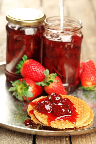 Potten van strawberry jam met bessen en wafeltjes op dienblad close-up — Stockfoto