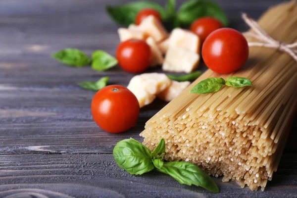 Pâtes crues aux tomates et au fromage sur fond de bois — Photo