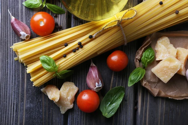 Raw pasta with cheese and vegetables on wooden background — Stock Photo, Image