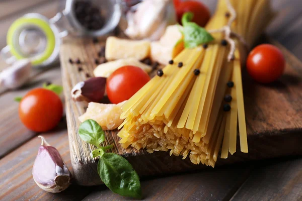 Pastas crudas con queso y verduras sobre fondo de madera —  Fotos de Stock