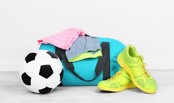 Sports bag with sports equipment in room — Stock Photo, Image