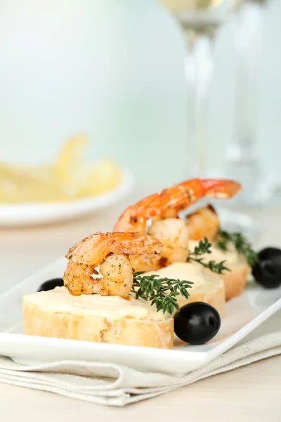 Appetizer canapé com camarão e azeitonas na mesa sobre fundo claro — Fotografia de Stock