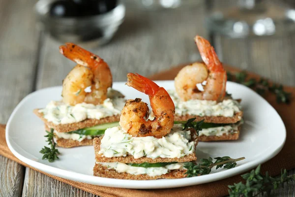 Appetizer canape with shrimp and cucumber on plate on table close up — Stock Photo, Image