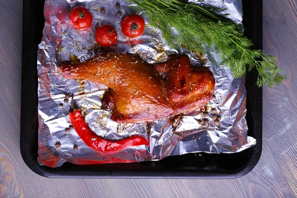 Smoked chicken leg with cherry tomatoes on pan on table close up — Stock Photo, Image