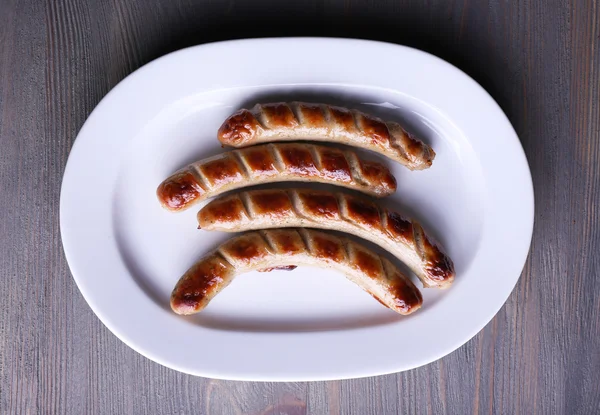 Grilled sausages on plate on table close up — Stock Photo, Image
