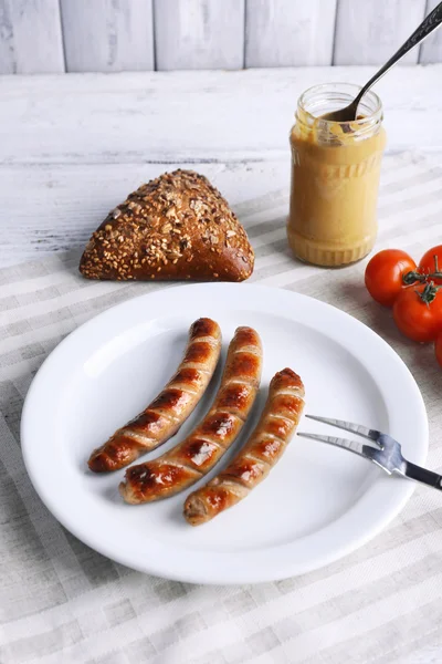 Ekmek ile plaka üzerinde ızgara sosis ve domates tablo üzerinde kapat