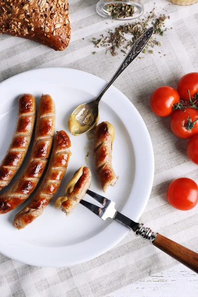 グリル ソーセージとパン皿の上、テーブルの上のチェリー トマトをクローズ アップ — ストック写真