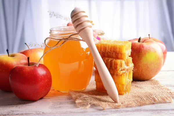 Delicious medu s jablky na tabulce na světlé pozadí — Stock fotografie