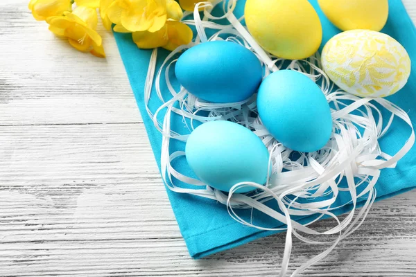 Composition de Pâques avec œufs colorés sur serviette sur fond de table en bois — Photo