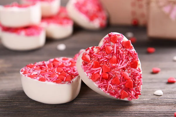 Delicious chocolate candies in heart shape on table close-up — Stock Photo, Image