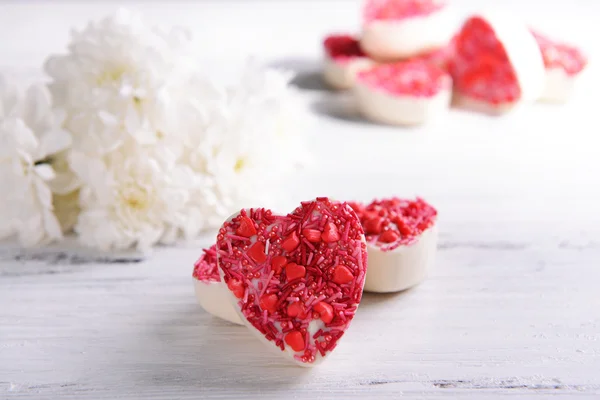 Delicious chocolate candies in heart shape on table close-up — Stock Photo, Image