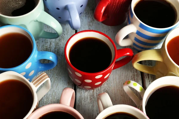 Veel kopjes koffie op houten tafel, close-up — Stockfoto