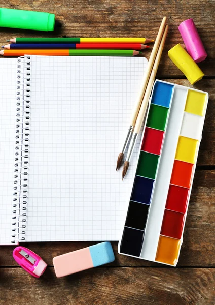 Notebook and bright school stationery on old wooden table — Stock Photo, Image