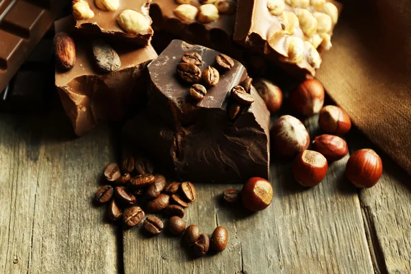 Bodegón con conjunto de chocolate con nueces en la mesa de madera, primer plano —  Fotos de Stock